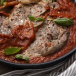 Succulent Italian beef stew with tomatoes, herbs, and spices in a black skillet, ready to serve. Perfect comfort food for hearty dinners.