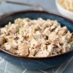 Creamy chicken salad with chopped celery and herbs in a blue ceramic bowl, served as a savory appetizer or lunch option. Perfect for sandwiches or on its own, easy to make and full of flavor.