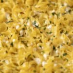 Creamy cheesy pasta with chopped chives, topped with melted cheese and herbs, perfect for comfort food dinners.