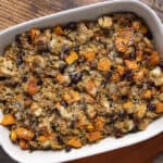 Savory turkey and vegetable rice casserole with sweet potatoes, cranberries, and herbs served in a white baking dish. Perfect for a comforting holiday meal or family dinner.