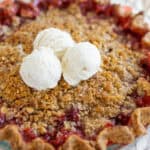 Golden-brown cherry crumb pie with a crispy crust topped with vanilla ice cream for dessert.