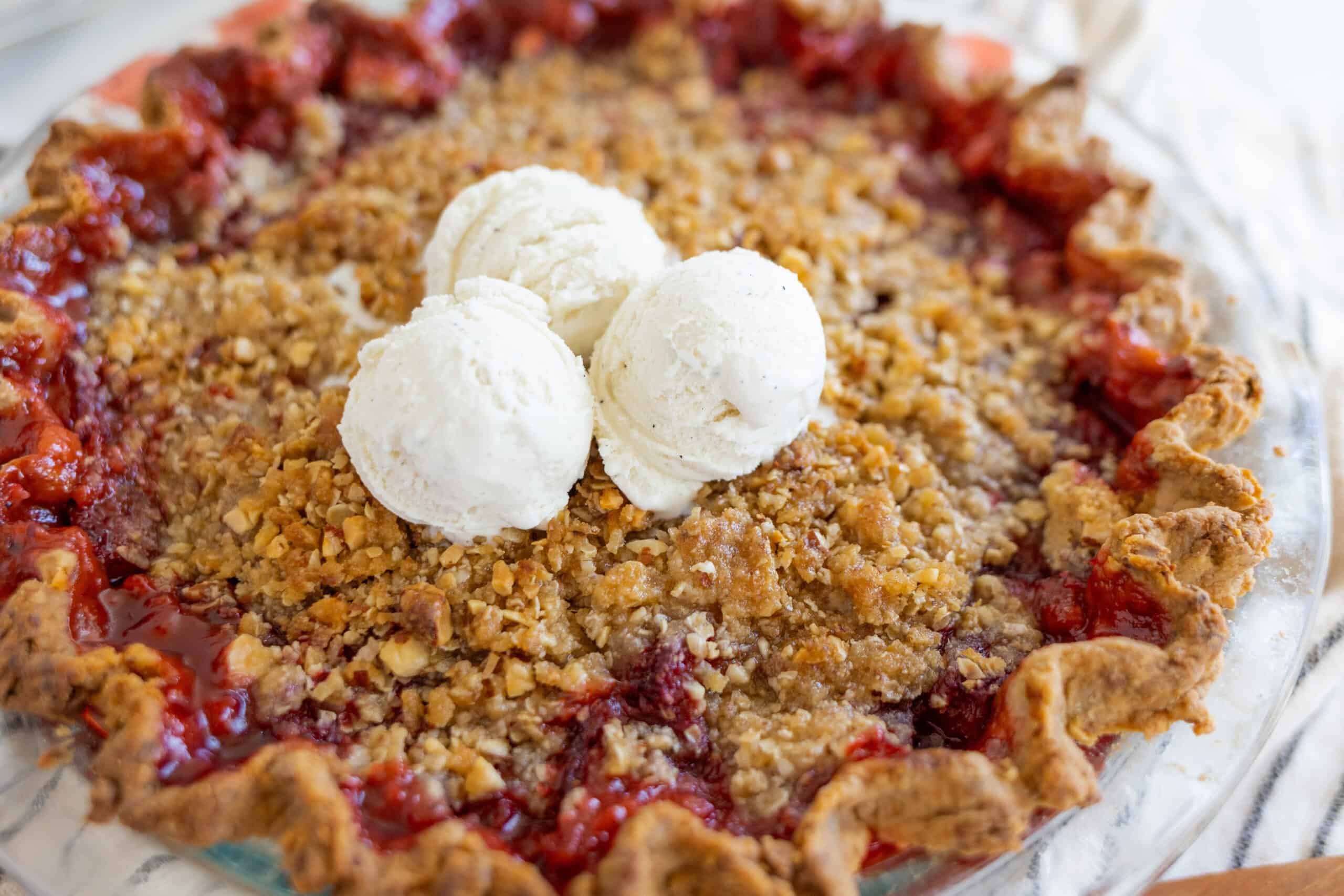 Golden-brown cherry crumb pie with a crispy crust topped with vanilla ice cream for dessert.