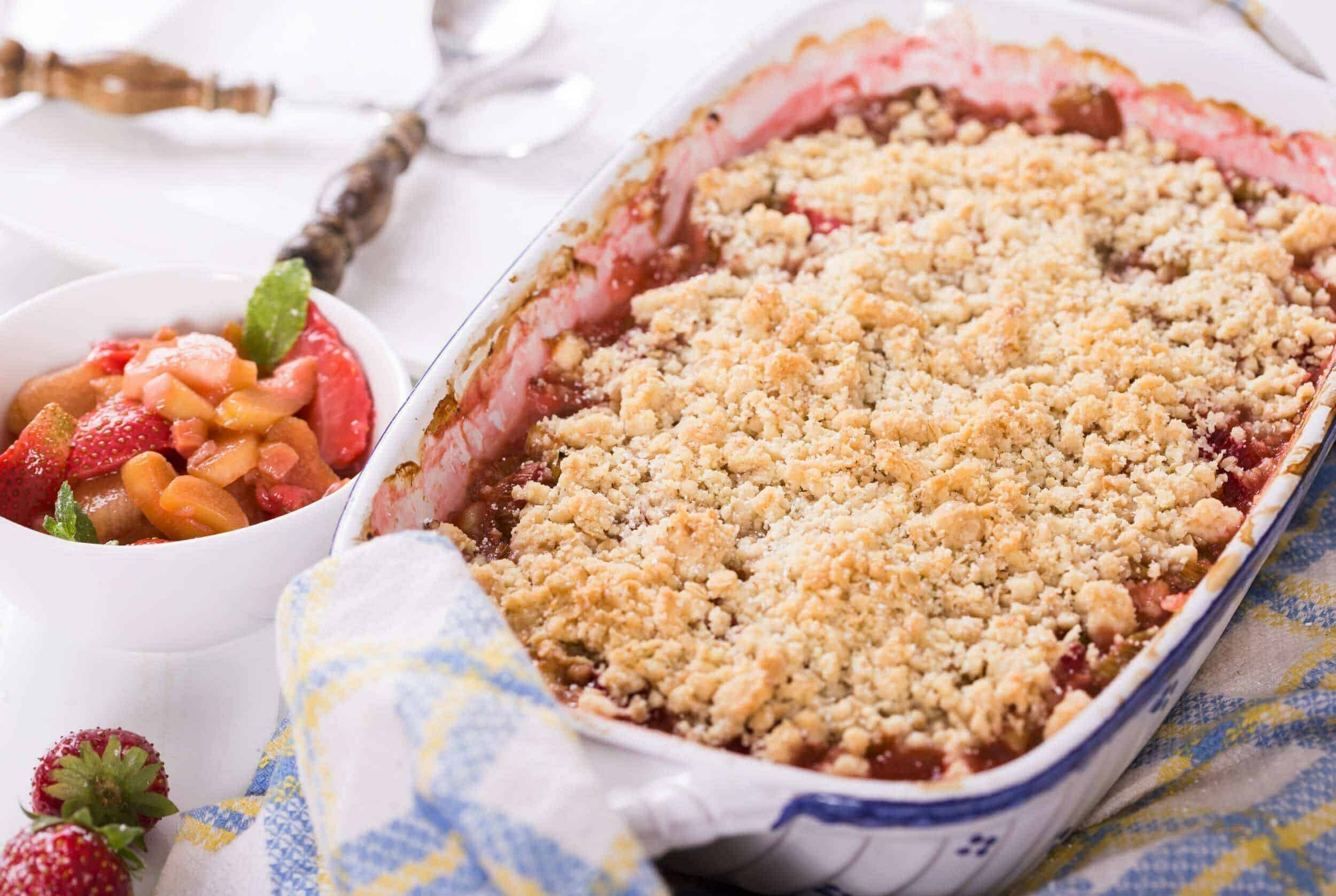 Fresh strawberry crumble dessert with fruit filling and crispy crumb topping, served with side of fresh strawberries. Perfect for summer fruit desserts and easy berry crumble recipes.