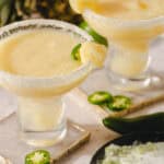 Creamy jalapeño margaritas garnished with lime and chili salt, served in salted rim glasses for a spicy citrus cocktail experience. Perfect for summer gatherings and festive occasions.