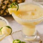 Creamy pineapple margarita cocktail with salted rim and lime garnish, served in a margarita glass, perfect for summer drinks and tropical parties.