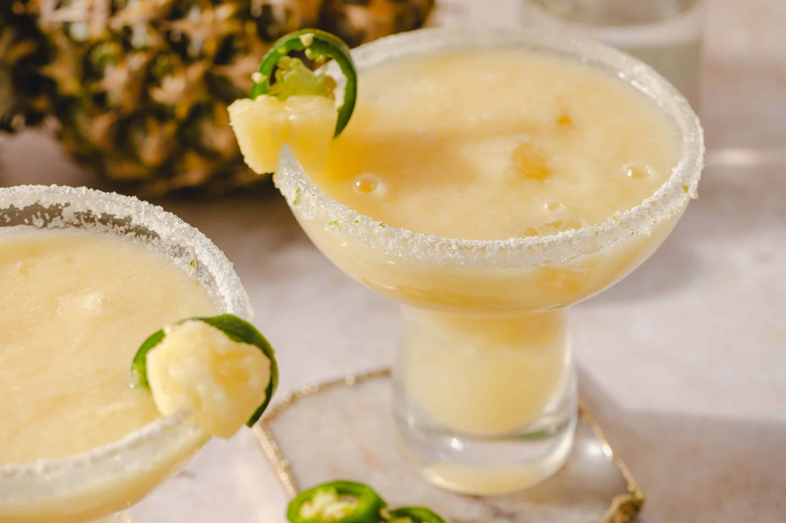 Creamy pineapple margarita cocktail with salted rim and lime garnish, served in a margarita glass, perfect for summer drinks and tropical parties.