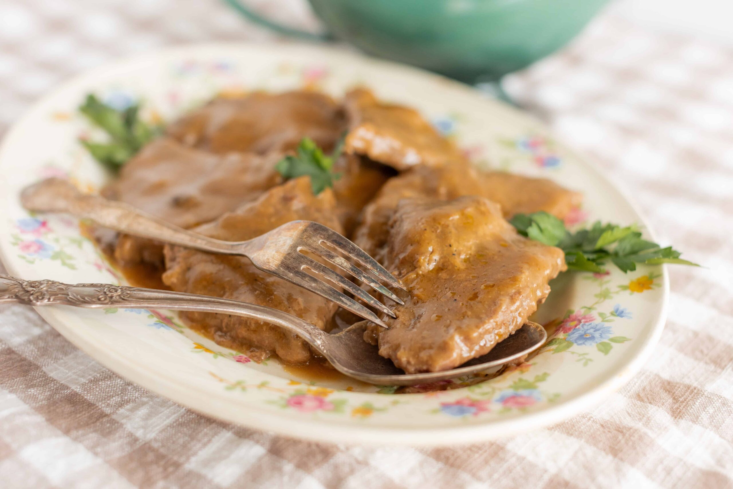 Succulent beef ribs covered in rich gravy served on a floral plate with fresh cilantro garnished. Perfect for hearty comfort food or a flavorful dinner, easy to prepare with simple ingredients.