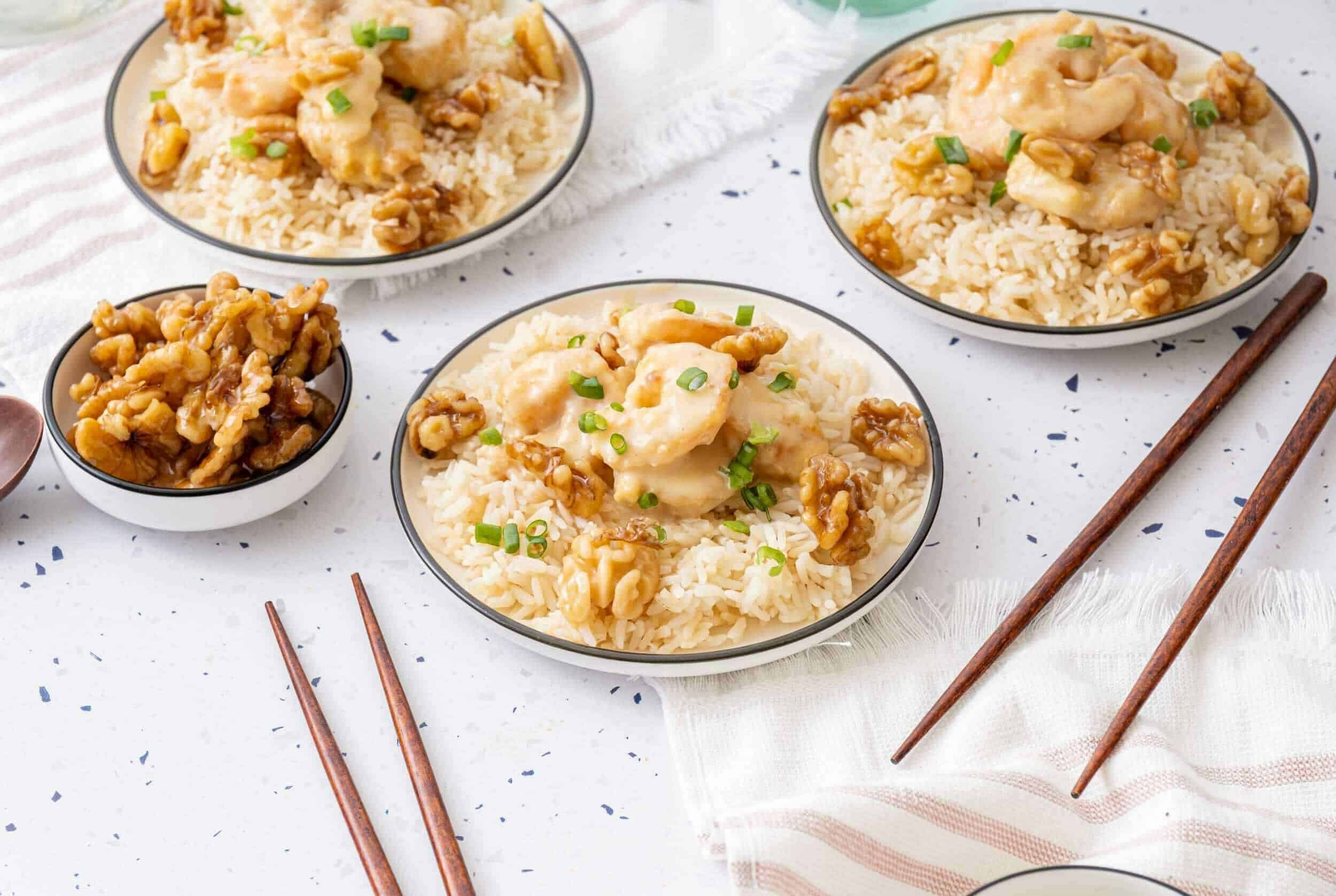 Creamy chicken and rice bowls with walnuts and green onions, garnished with fresh herbs. Perfect comfort food recipe for lunch or dinner.