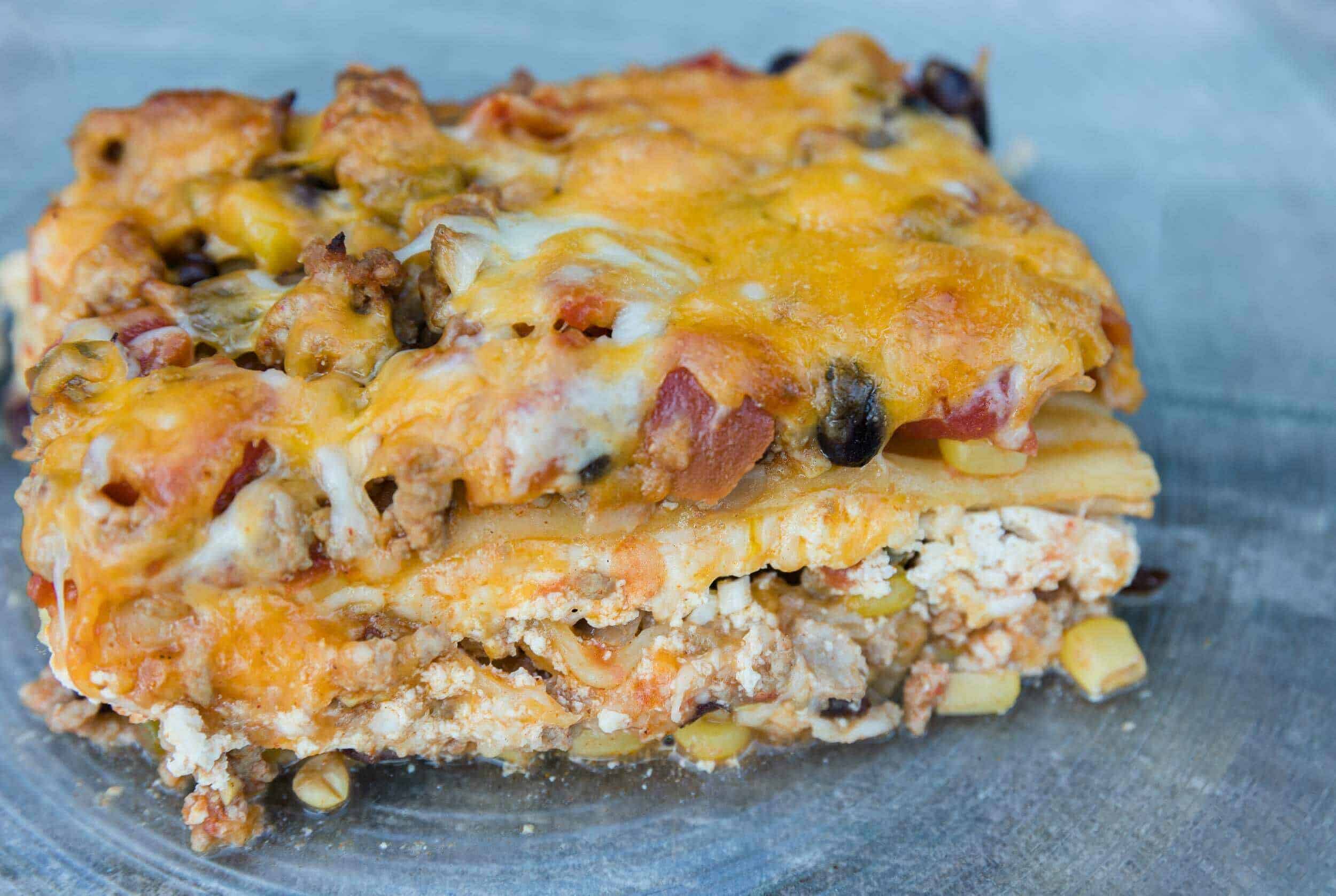 Cheesy layered casserole with ground meat, beans, and savory toppings, perfect for comfort food lovers.