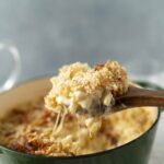 Creamy cheesy baked casserole with a golden breadcrumb topping served in a green cast iron skillet. Perfect comfort food recipe for family dinners or gatherings.