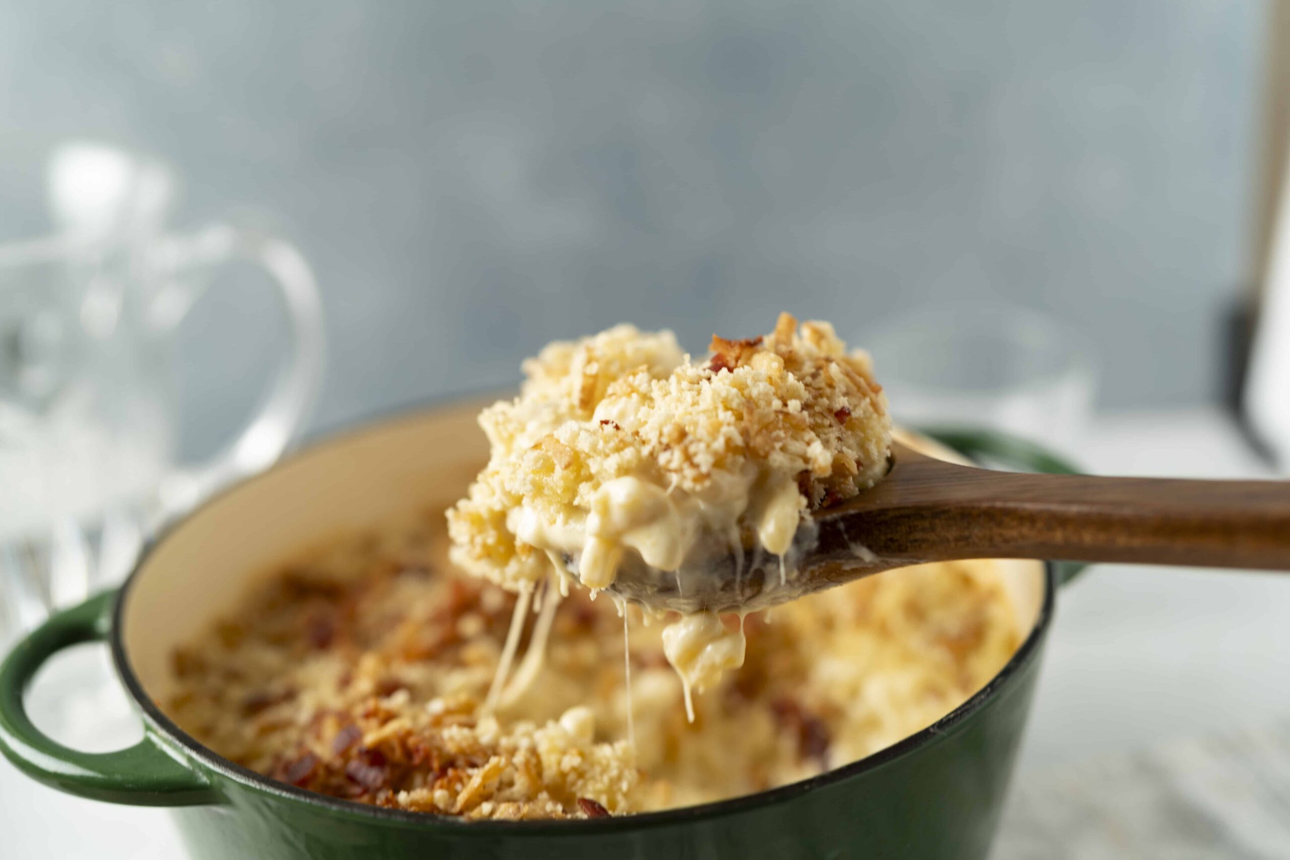 Creamy cheesy baked casserole with a golden breadcrumb topping served in a green cast iron skillet. Perfect comfort food recipe for family dinners or gatherings.