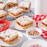 Colorful frosted sugar cookies with sprinkles and fruity filling, perfect for birthday parties and celebrations.