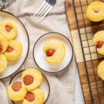 Cream cheese sausage mini muffins with hot dog filling, baked to golden perfection, served on plates and cooling rack. Perfect savory snack or appetizer, easy homemade recipe from Hey Recipe.