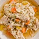 Savory chicken and vegetable soup, hearty homemade chicken noodle soup with carrots, celery, and herbs in a white bowl, healthy comfort food recipe, perfect for cold days and nutritious meals.