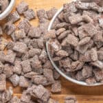 Crunchy, sugar-coated dried ginger pieces in bowls and scattered on a wooden surface, perfect for making ginger candies or snacks, showcasing a delicious homemade treat.