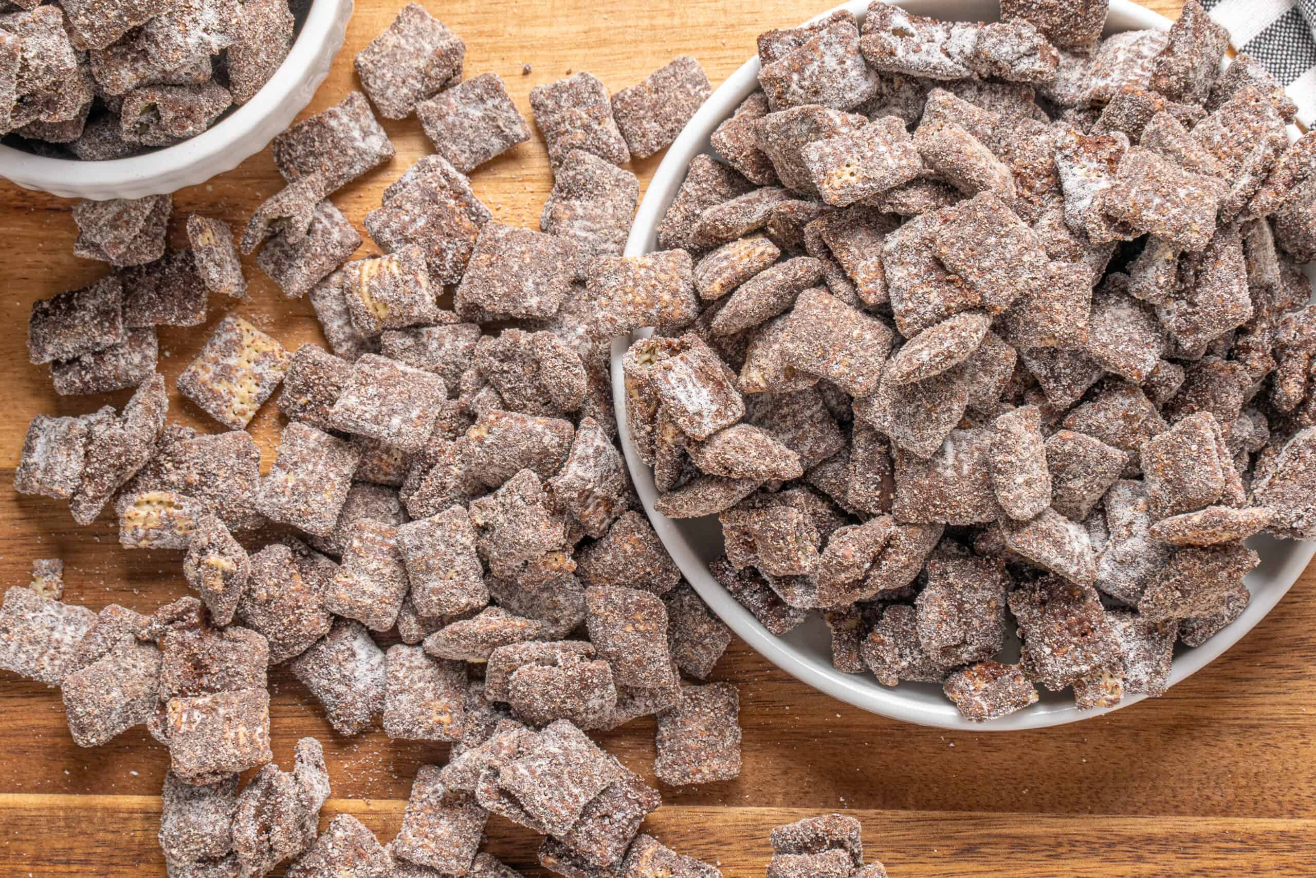 Crunchy, sugar-coated dried ginger pieces in bowls and scattered on a wooden surface, perfect for making ginger candies or snacks, showcasing a delicious homemade treat.