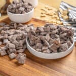 Dried candied ginger pieces on a wooden cutting board with bowls and chunks, ready to use in recipes, snacks, or baking.