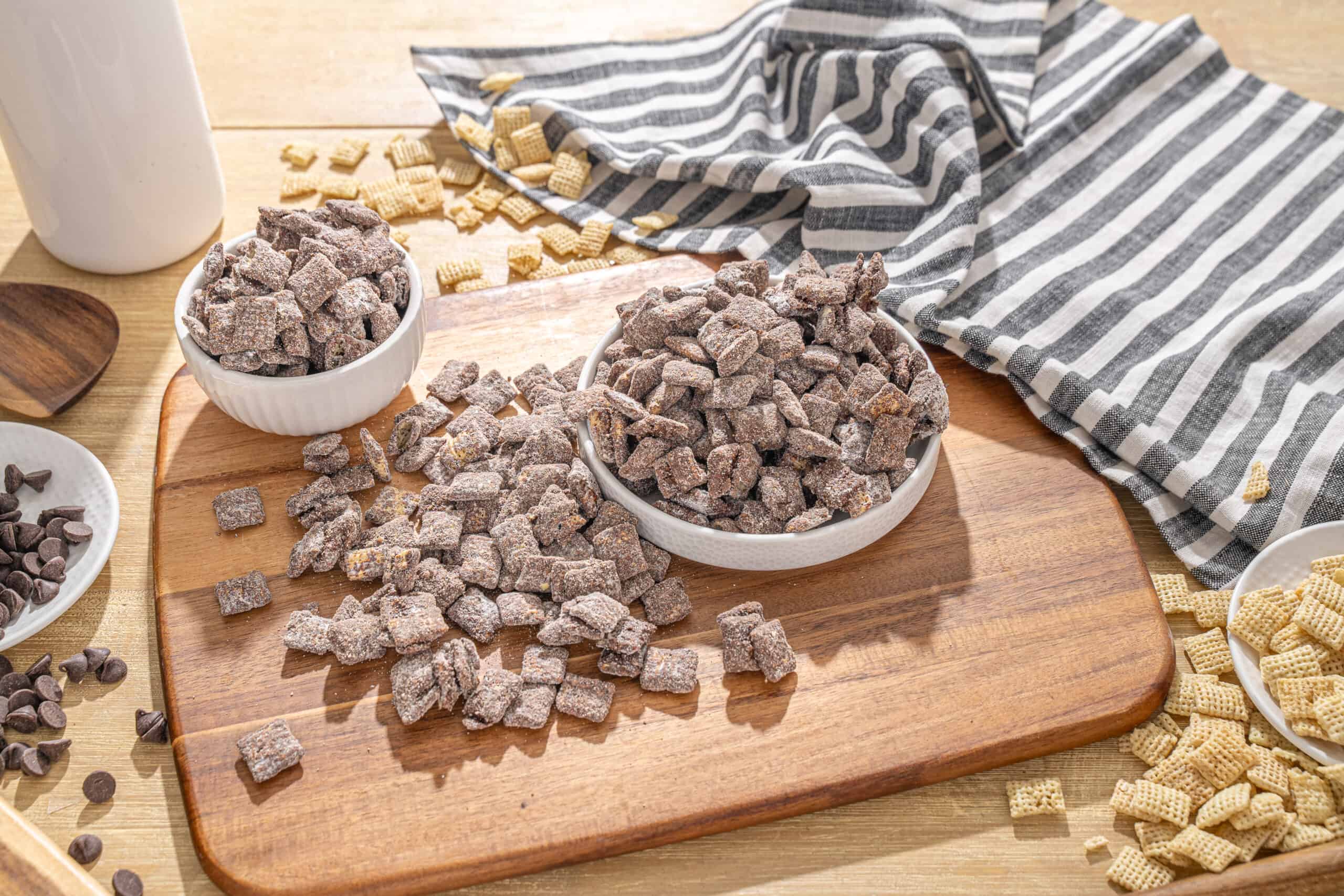 Colorful frozen snack cubes with raisins, chocolate chips, and biscuit pieces in bowls on a wooden cutting board. Perfect for quick and tasty treats or dessert toppings, ideal for quick snacks or creative dessert ideas.