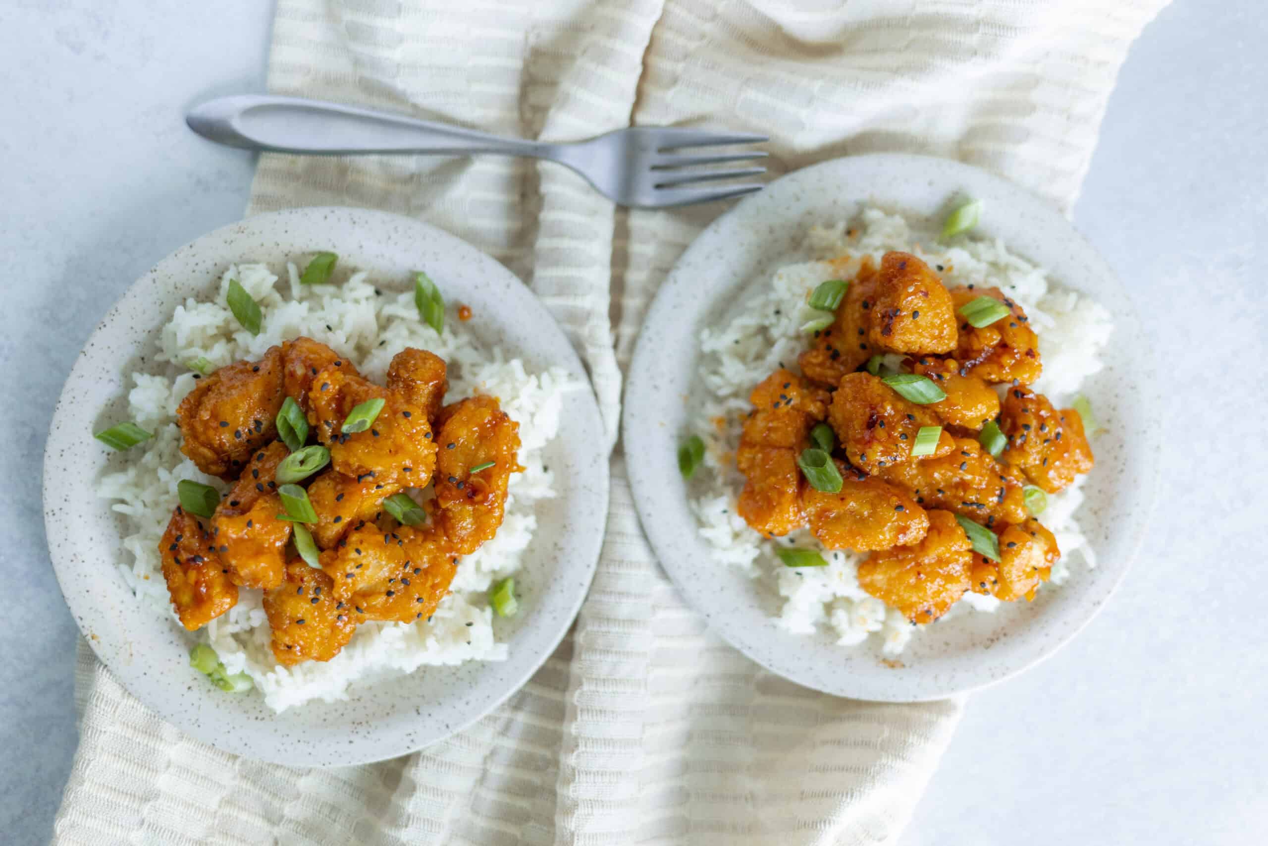 Juicy Asian-style honey garlic chicken served over steamed white rice garnished with green onions. Perfect for quick and flavorful dinner recipes or meal prep.