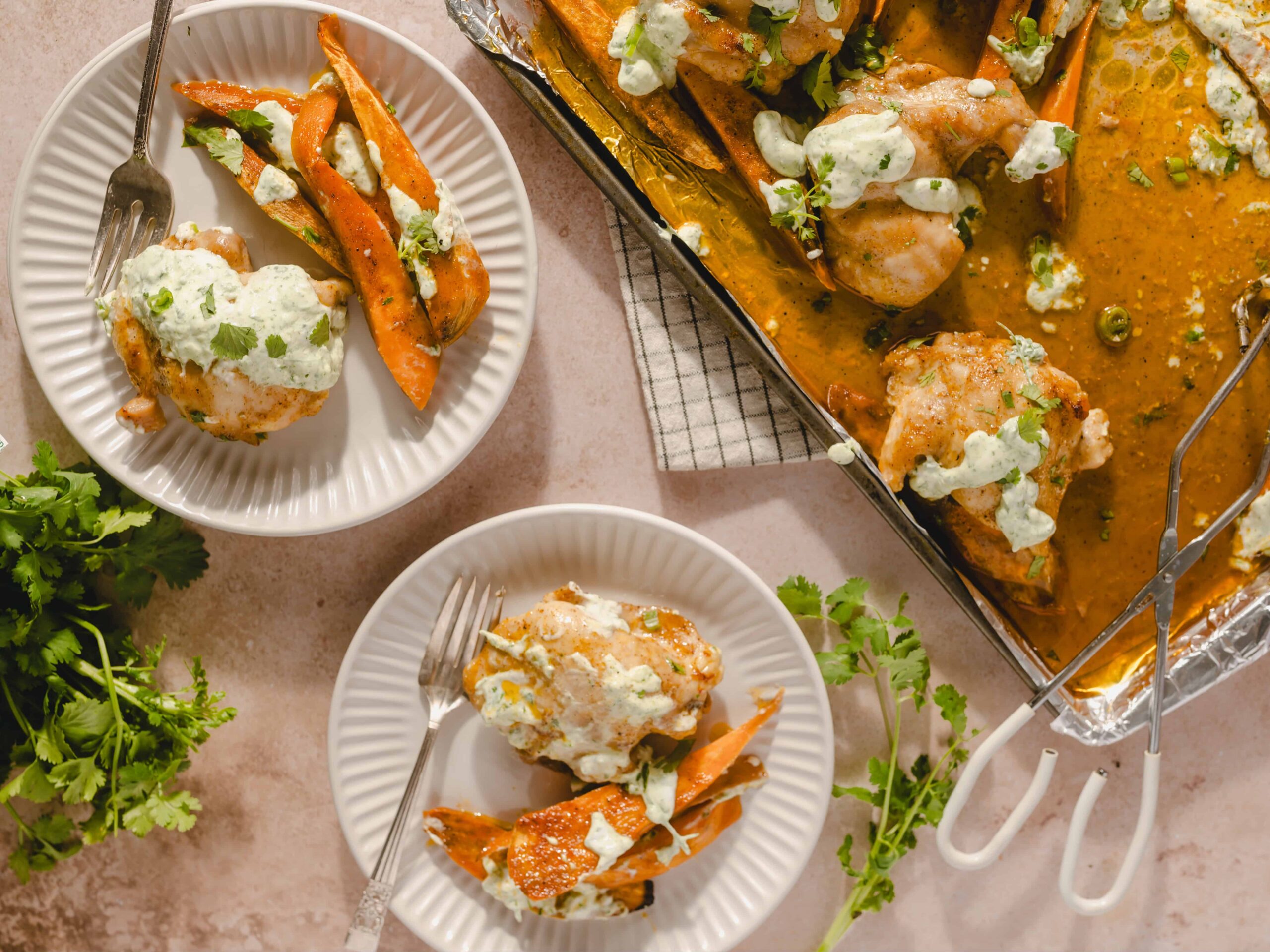 Creamy chicken and roasted carrots served with cilantro sauce on white plates, fresh cilantro garnish, and a baking dish with tender chicken pieces in rich sauce, perfect for dinner.
