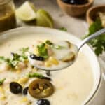Creamy fish chowder with corn, black olives, sliced jalapeños, and fresh herbs in a rustic bowl. Perfect for seafood lovers, this comforting soup features a rich, flavorful broth with vibrant toppings.