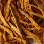 Golden roasted sweet potato fries seasoned with herbs and spices, crispy on the outside, tender inside, perfect for healthy snacks or side dishes.