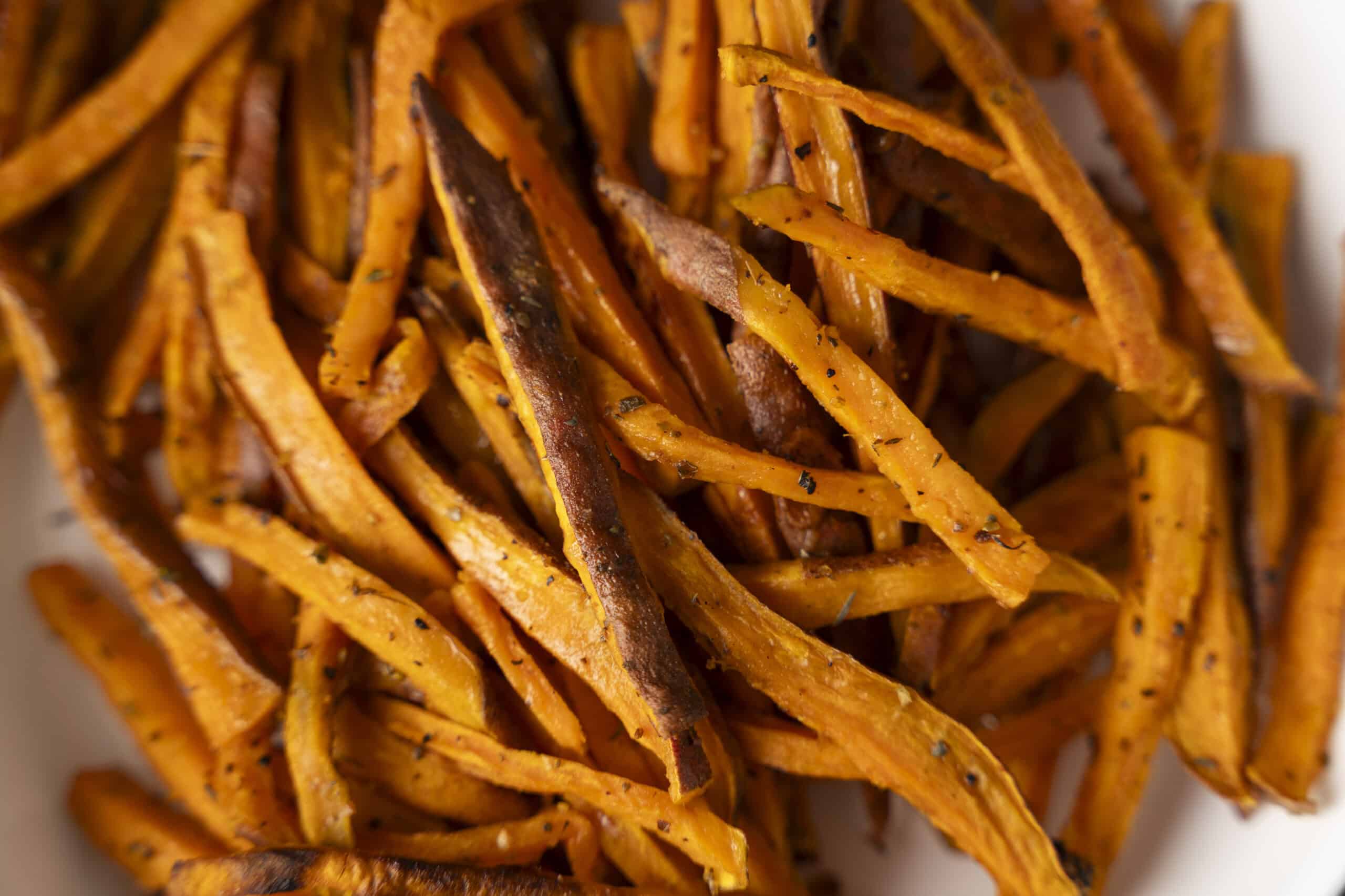 Golden roasted sweet potato fries seasoned with herbs and spices, crispy on the outside, tender inside, perfect for healthy snacks or side dishes.