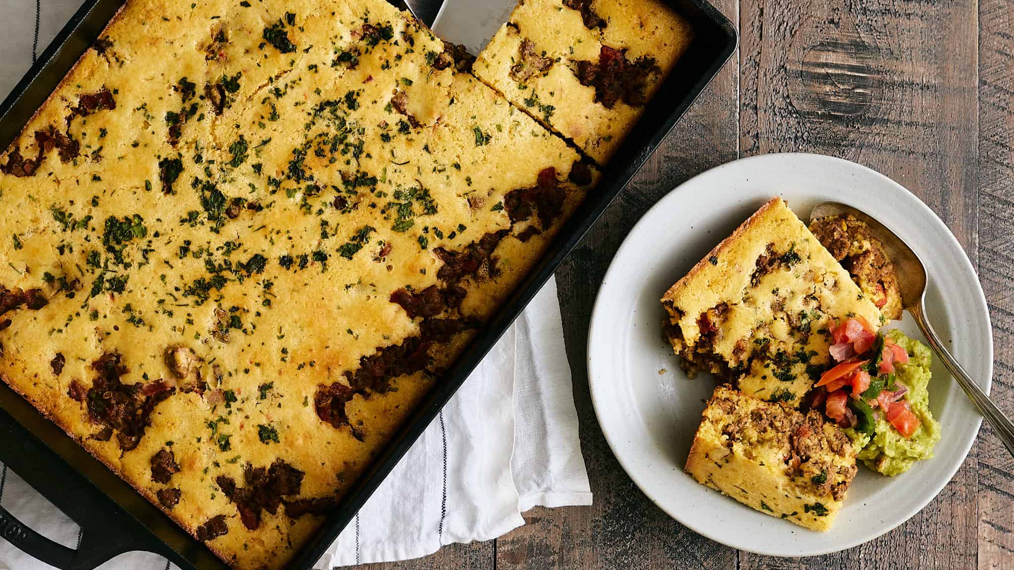 Golden baked dish with beef, cheese, and herbs in a black baking dish.