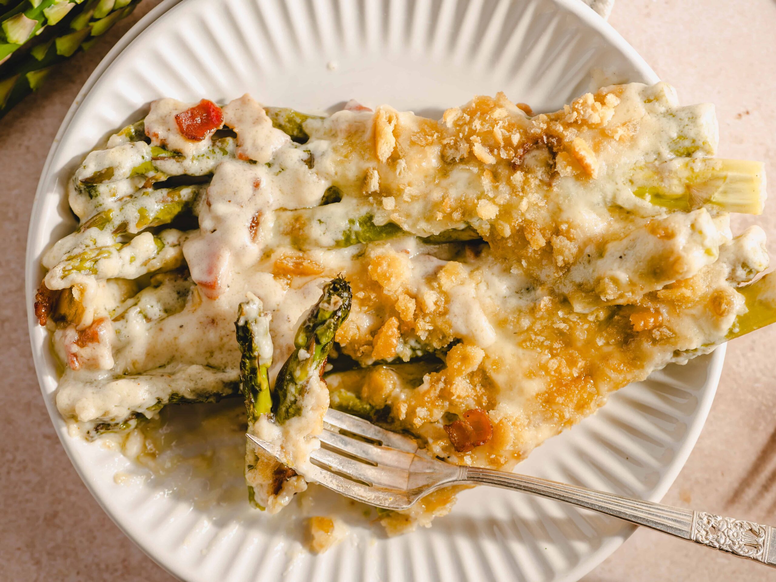 Creamy baked asparagus with cheese and crispy topping, served on a white plate. Perfect for healthy dinner or appetizer, highlighting cheesy asparagus recipes.