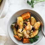 Roasted vegetable chicken casserole served with pumpkin, sweet potatoes, zucchini, and kale, topped with pumpkin seeds and fresh parsley for a healthy and delicious meal.