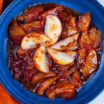 Soft poached pears in a rich caramel sauce served on a blue plate. Perfect for dessert or a sweet snack, easy to make with fresh pears and sweetened caramel.