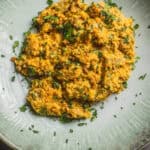 Creamy ground turkey migas served with fresh herbs on a ceramic plate - a healthy, flavorful Mexican breakfast or dinner option.
