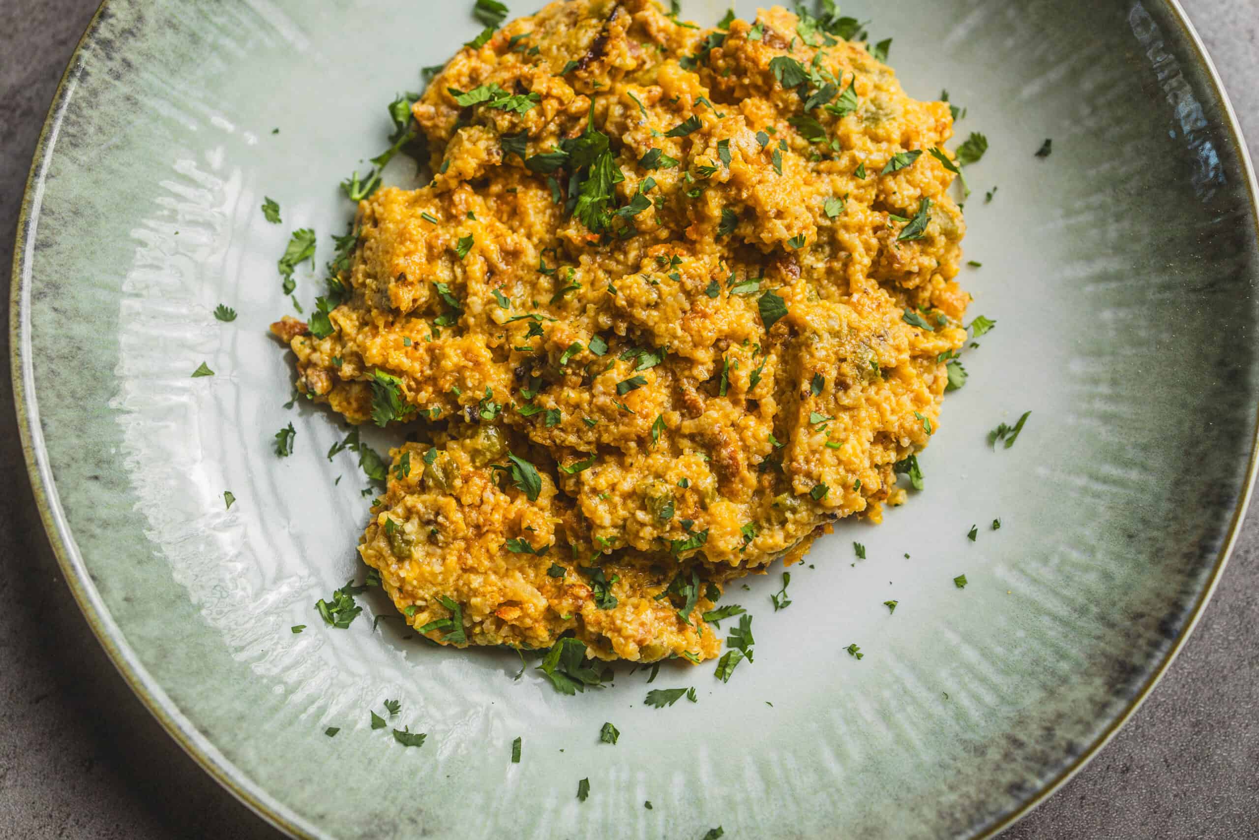 Creamy ground turkey migas served with fresh herbs on a ceramic plate - a healthy, flavorful Mexican breakfast or dinner option.