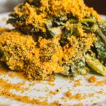 Crispy fried spinach with golden breading on white plate, healthy vegetarian appetizer, close-up of crunchy spinach leaves coated in seasoned breadcrumbs, perfect for a nutritious snack or side dish.