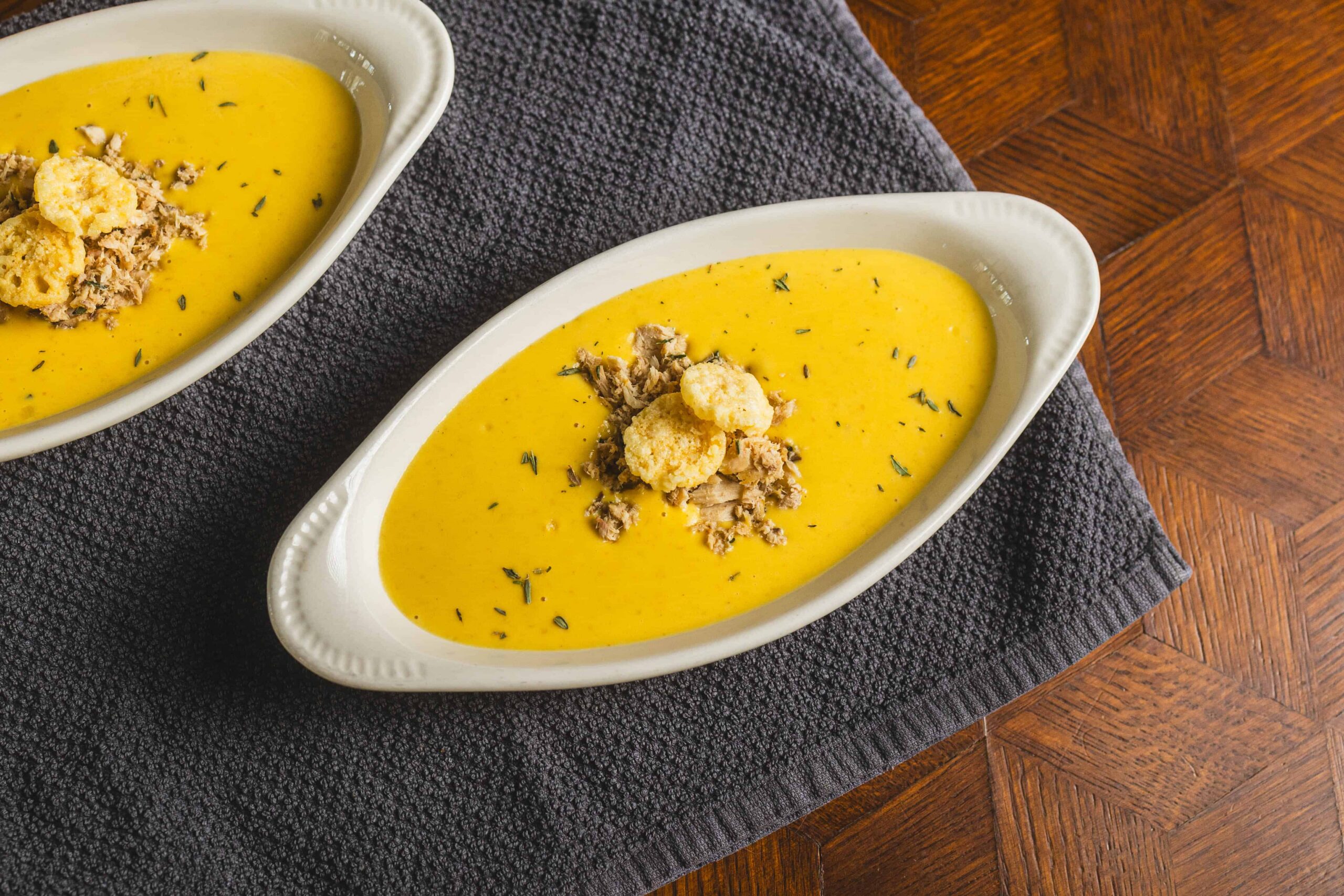 Creamy butternut squash soup topped with shredded chicken, croutons, and herbs in a white oval bowl. Perfect for warm, comforting meals and easy to prepare with fresh ingredients.
