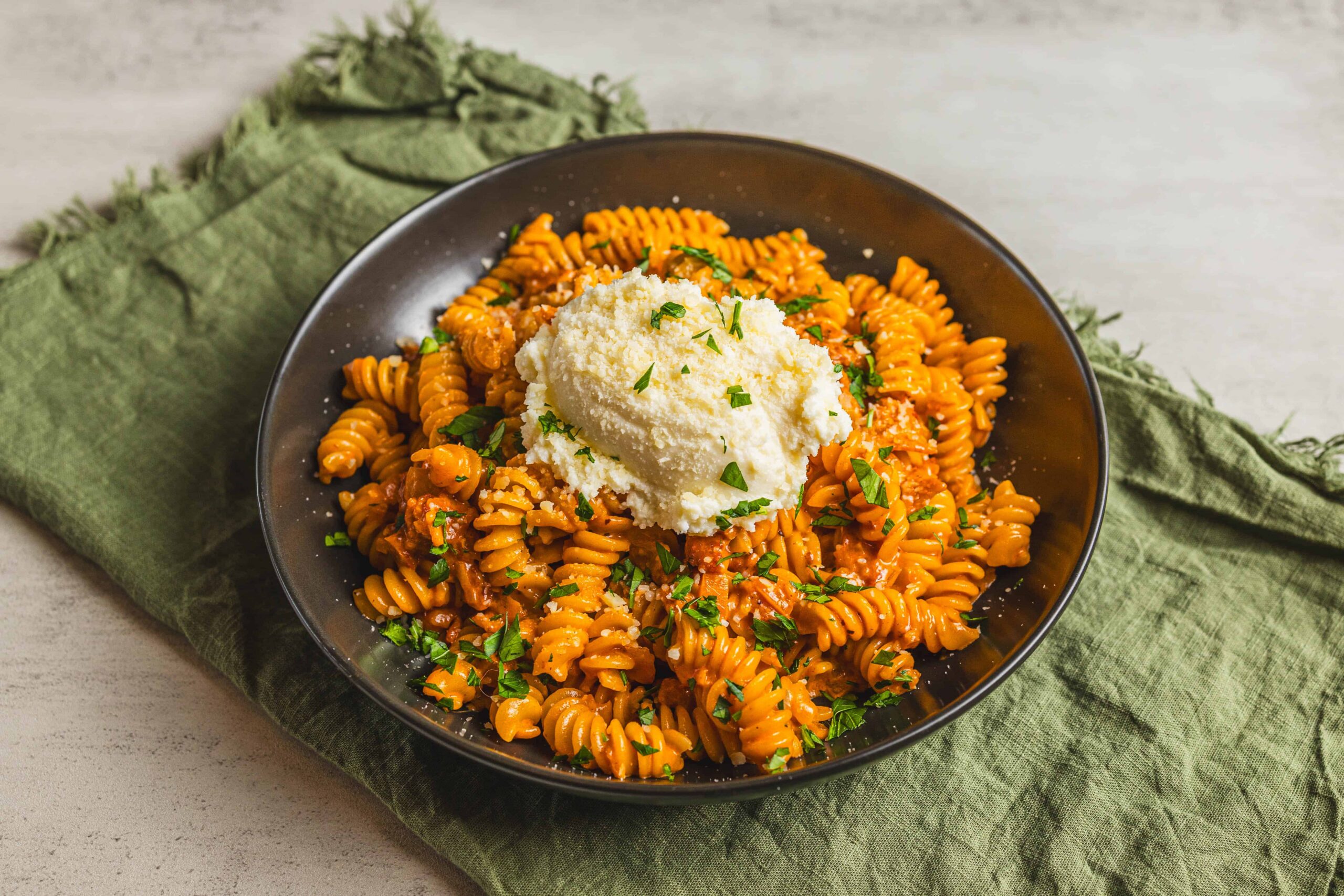 Creamy tomato basil pasta with rotini, topped with grated parmesan cheese and fresh chopped parsley - quick and easy comfort food recipe.