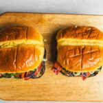 Crispy grilled veggie burgers with fresh toppings on a wooden cutting board, served as vegetarian fast food or plant-based meal options vegan friendly and delicious.