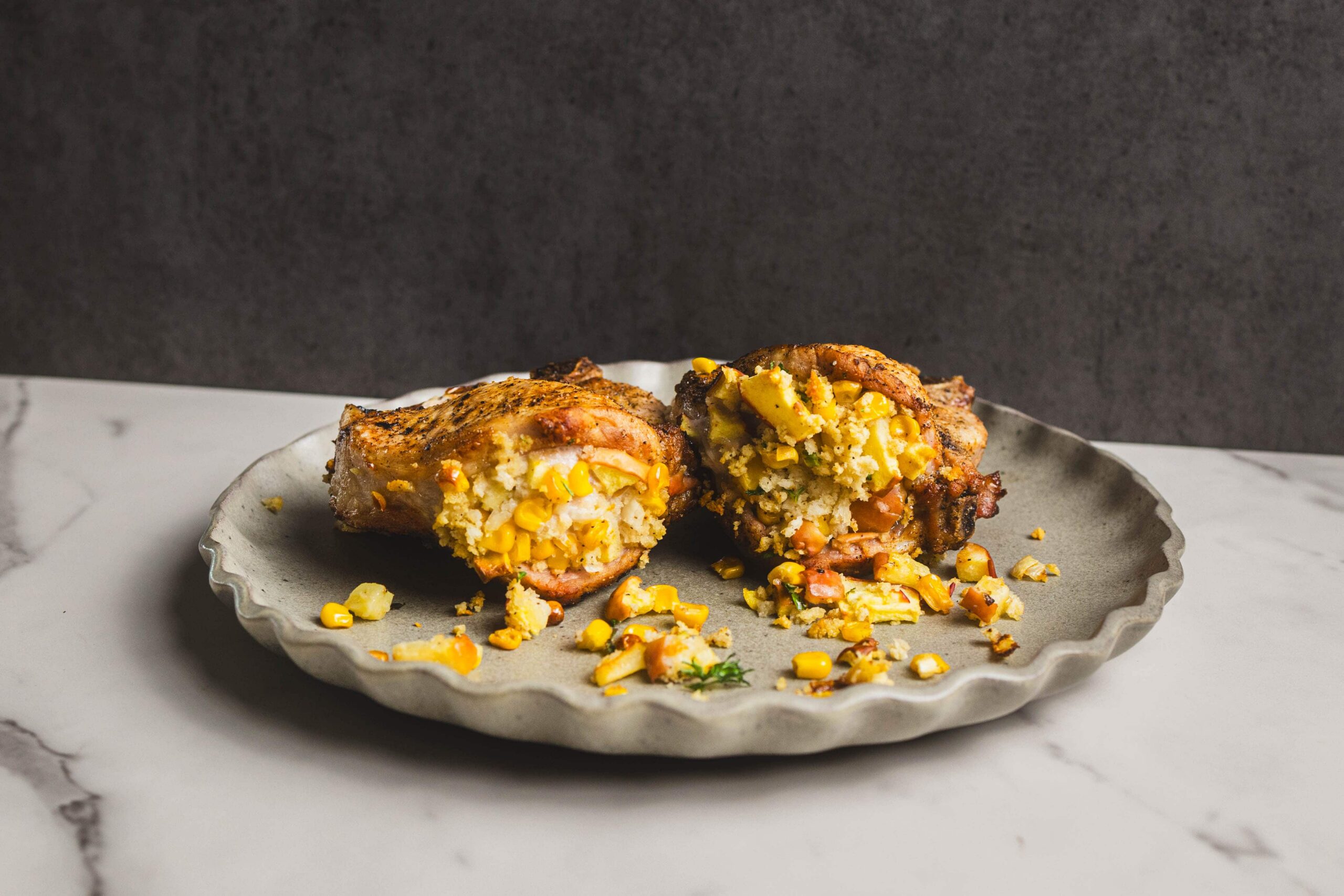 Baked chicken breast stuffed with corn, cheese, and herbs on a rustic plate, served as a savory and flavorful comfort food dish.
