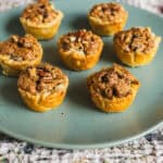 Mini apple cobbler muffins with streusel topping on a teal plate, perfect for fall dessert recipes, easy apple dessert ideas, and quick muffin baking sweet treats.