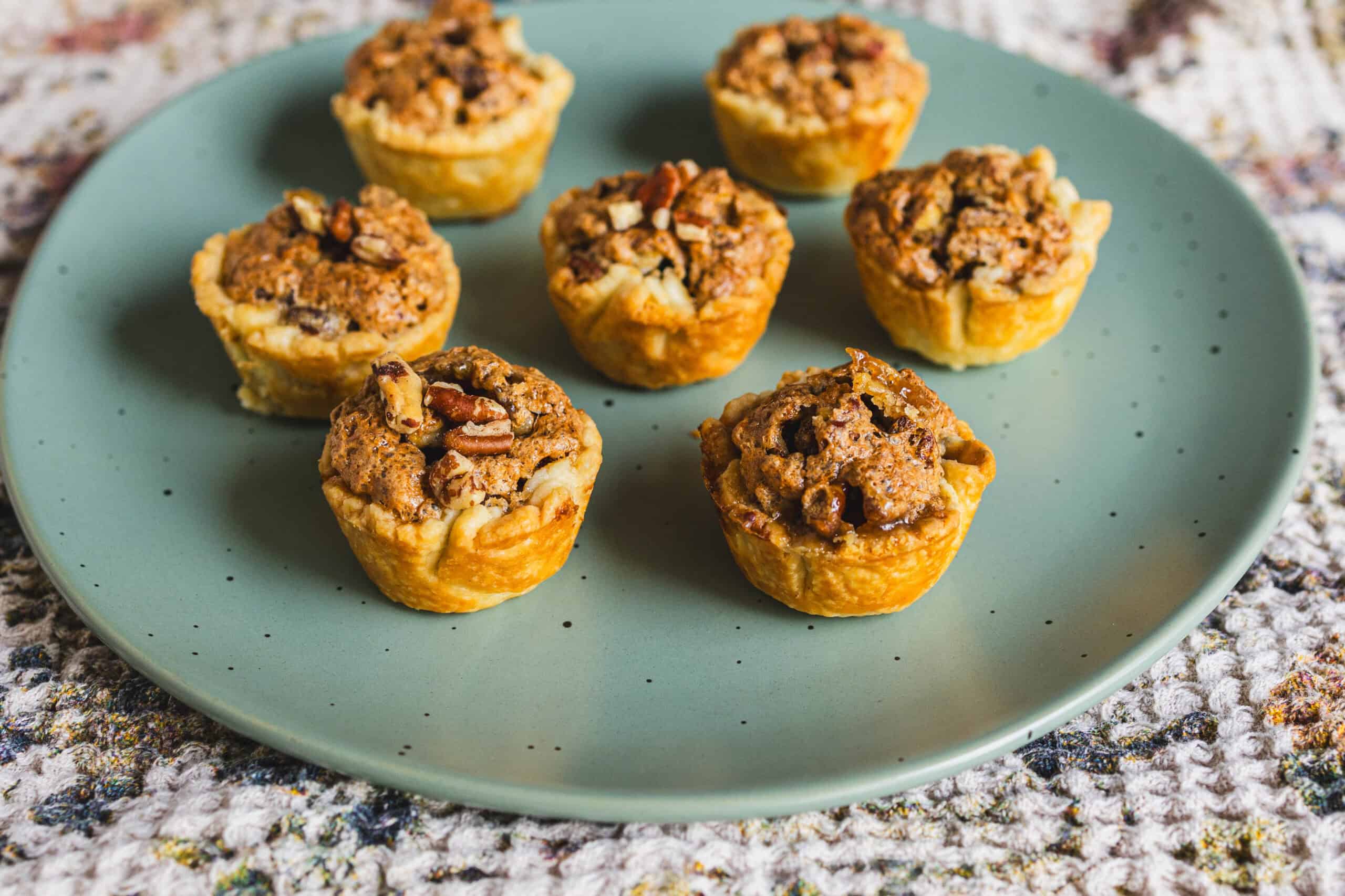 Mini apple cobbler muffins with streusel topping on a teal plate, perfect for fall dessert recipes, easy apple dessert ideas, and quick muffin baking sweet treats.