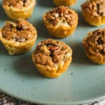 Chocolate chip muffin cups with crunchy crumble topping on a mint green plate, perfect for breakfast or snack. Homemade muffin cups filled with rich chocolate chips and a crispy topping.