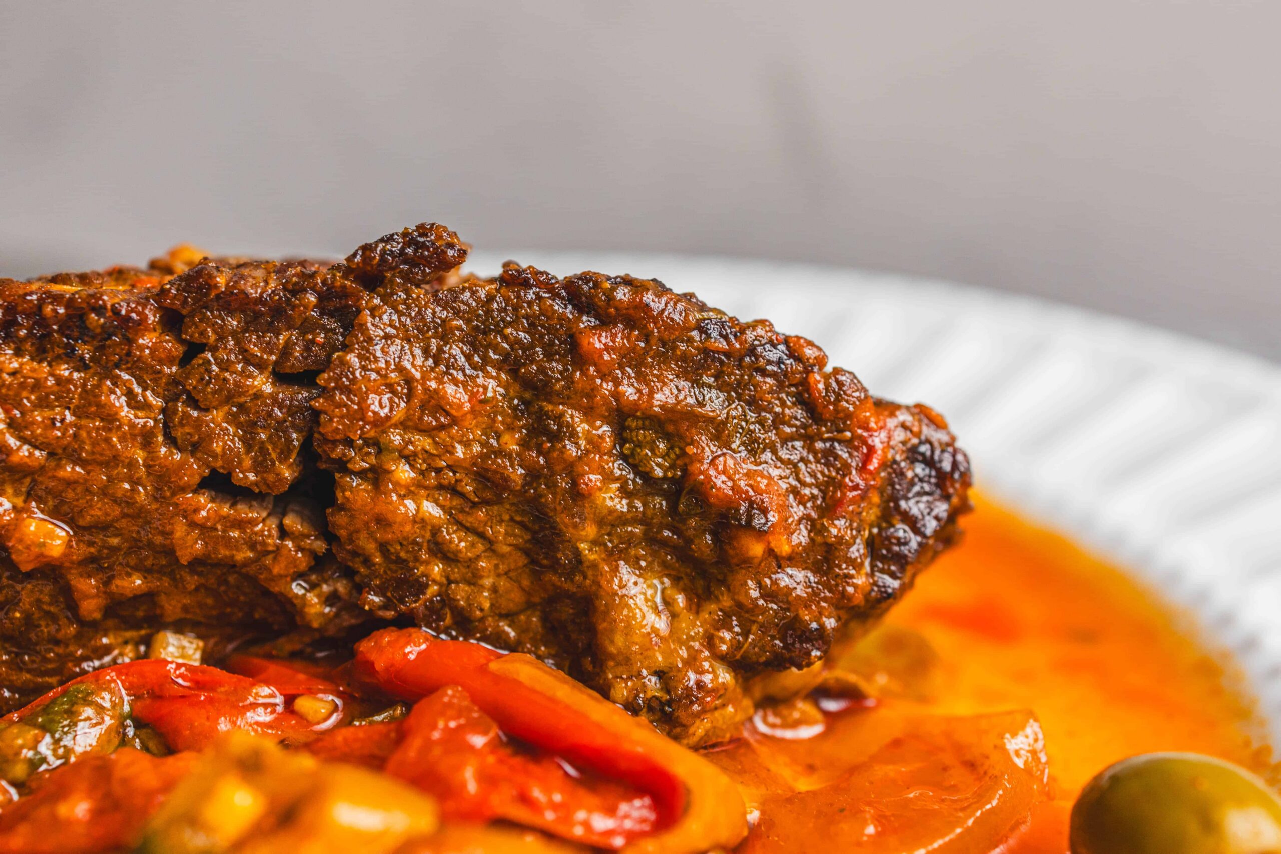 Juicy beef meatloaf with savory tomato-based sauce served on a white plate, highlighting a delicious homemade comfort food meal.