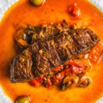 Savory fish stew with tender fish fillet, vegetables, and flavorful broth garnished with olives and herbs. Perfect for seafood lovers and hearty meal enthusiasts.