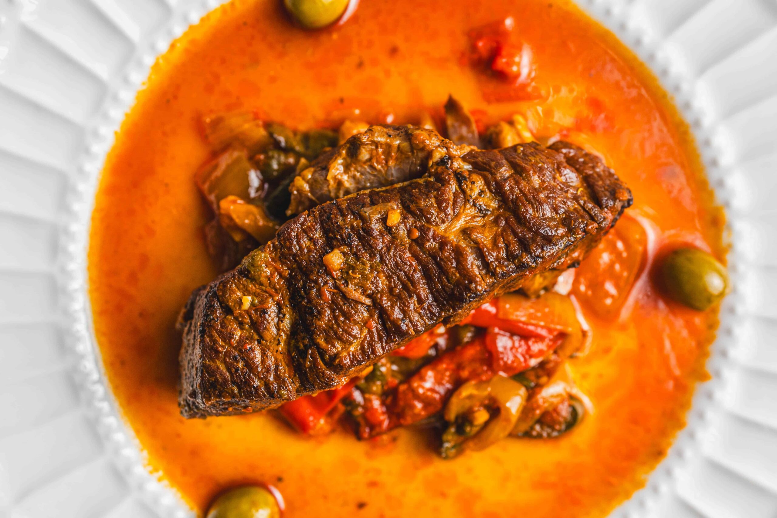 Savory fish stew with tender fish fillet, vegetables, and flavorful broth garnished with olives and herbs. Perfect for seafood lovers and hearty meal enthusiasts.
