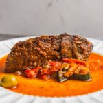 Braised beef stew with vegetable sauce served on a white plate; hearty, flavorful, and perfect for comfort food recipes.