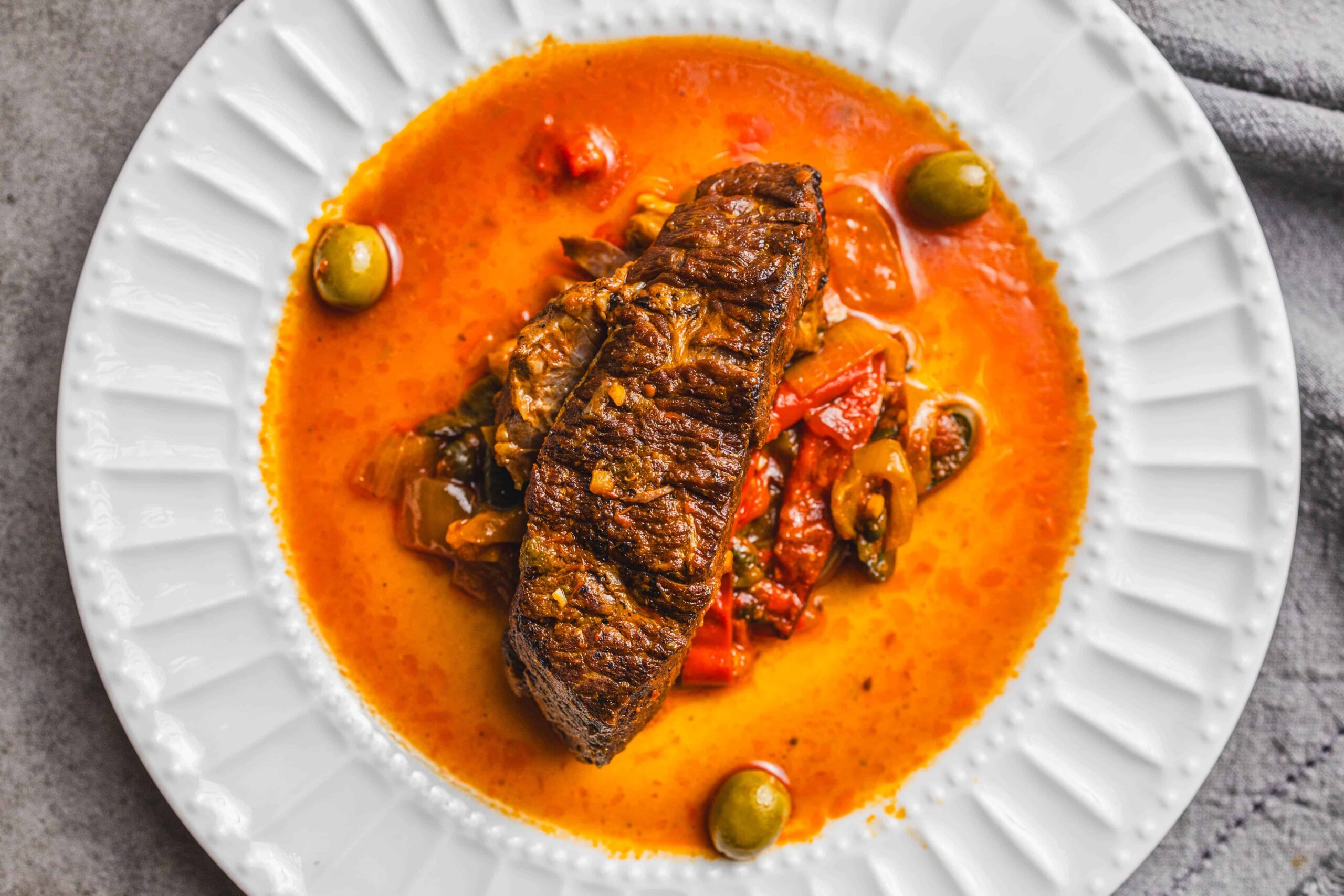 Freshly cooked beef stew with vegetables in rich, flavorful sauce served on a white ceramic plate. Perfect comfort food for dinner.