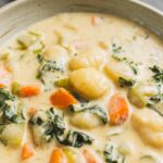Creamy vegetable and potato stew with carrots, kale, and herbs in a rustic bowl for a comforting, hearty meal. Perfect for cold days or when craving healthy, flavorful comfort food.